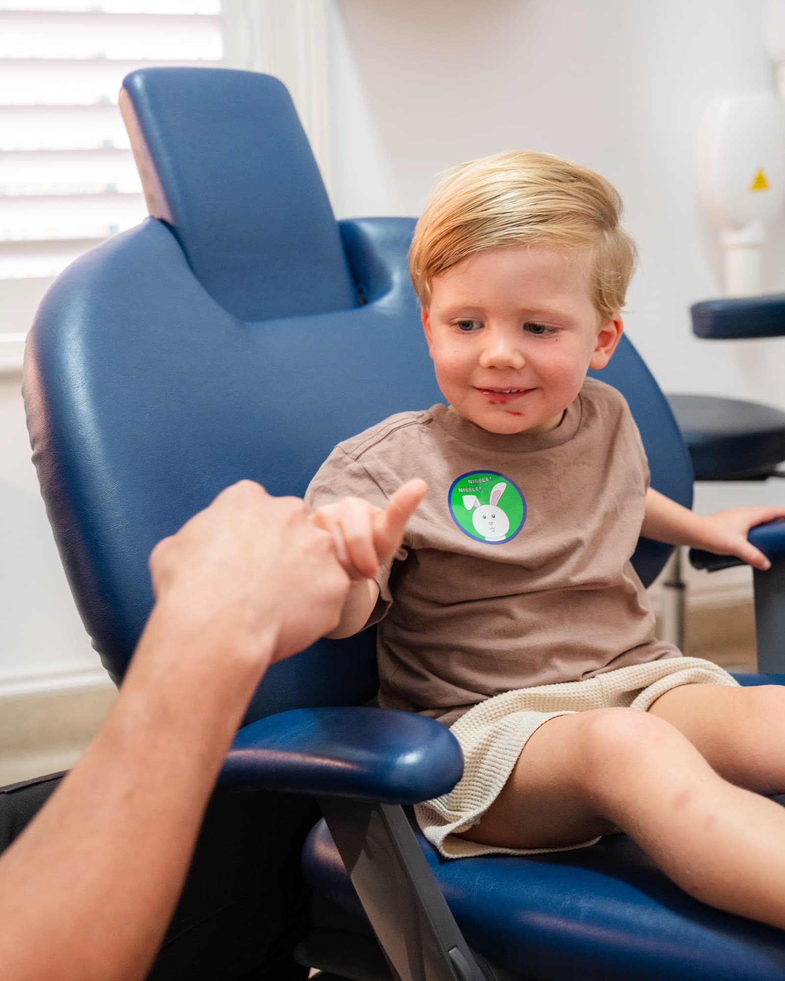 A young patient receiving a sticker reward at Dora Street Dental