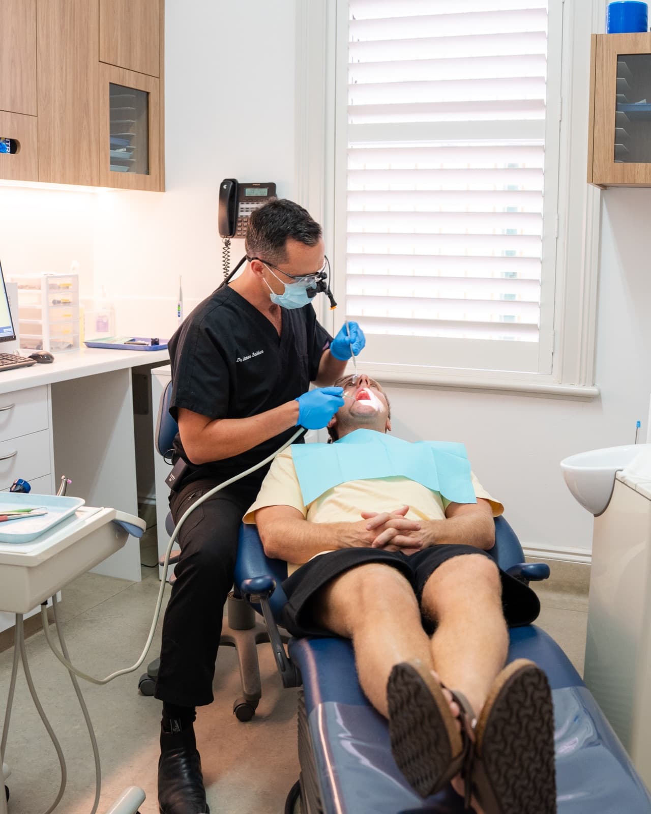 Dr James Bakker treating a patient by the window